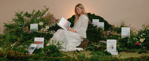 Model sitting and reading an Alabaster Bible in a green setting